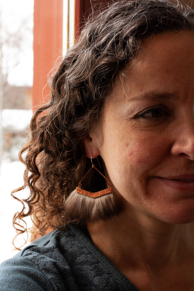 Yes, you can wear statement earrings with curly hair